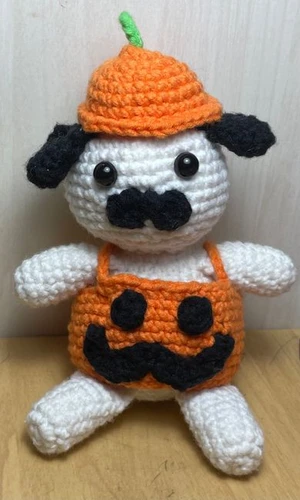 Sitting down pug with removable pumpkin suit and hat