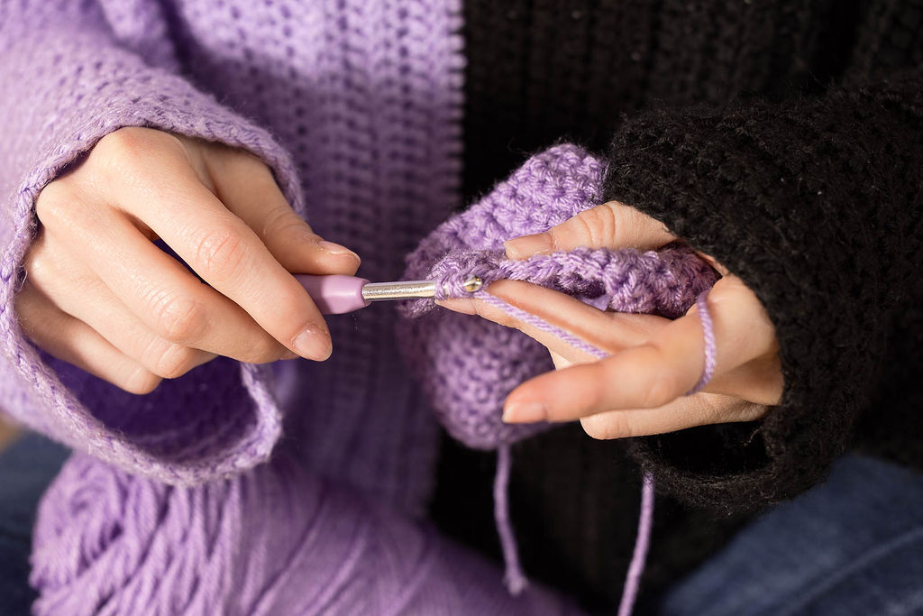 Maker crocheting with purple yarn